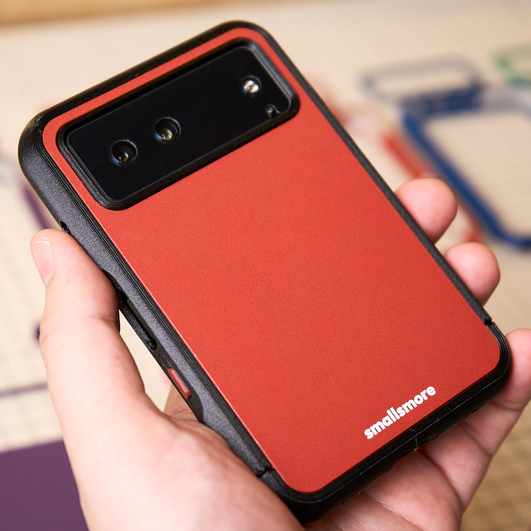 A black frame and red backplate held in hand